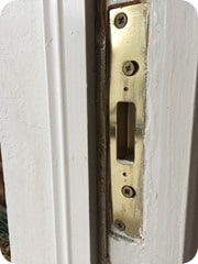Dead bolt strike plate in door frame
